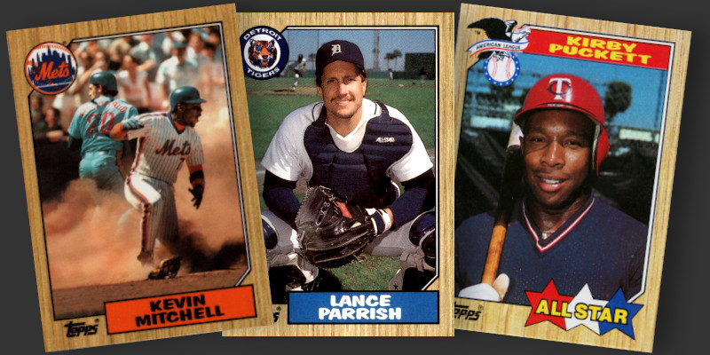 Image: Three 1987 Topps baseball cards. Cards pictured are Kevin Mitchell (emerging from a cloud of dust in a play at the plate), Lance Parrish (in a squatting catcher pose evocative of the style used in 1962 Topps), and a Kirby Puckett A--Star subset card (with bright red white and blue design elements and an American League logo)