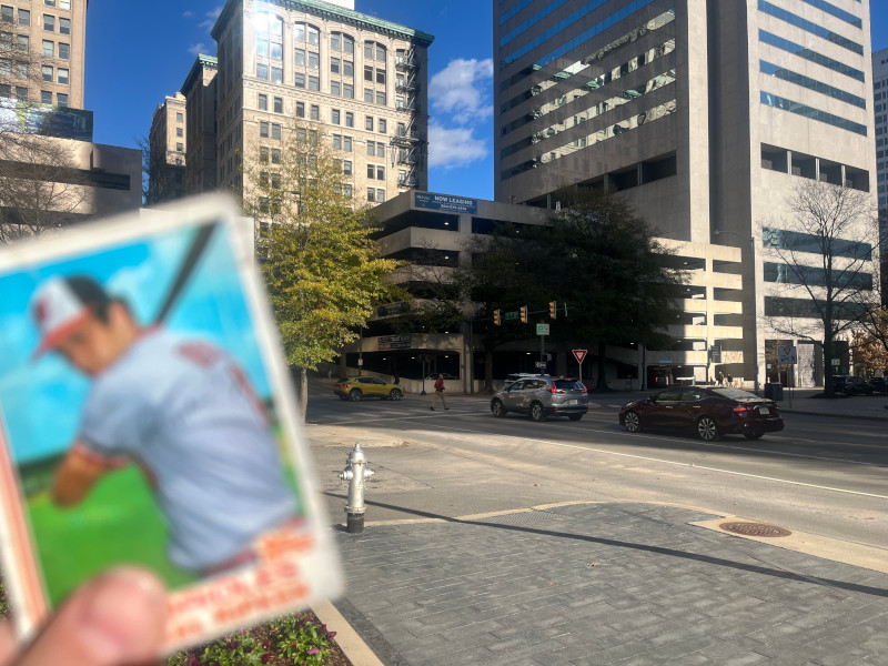 [Image: Cal Ripken card held up in front of the former site of the American Tobacco Company's primary factory in Richmond, Virginia.]